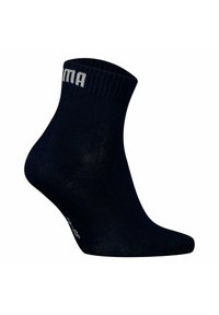 Navy anklestrumpa gjord av ett slätt, stretcht material, med en ribbad manschett och en kontrasterande vit logotyp på sidan.