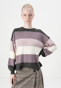 Purple and black striped sweater with ribbed texture, round neckline, and dropped shoulders. Paired with a plaid skirt featuring a belt.