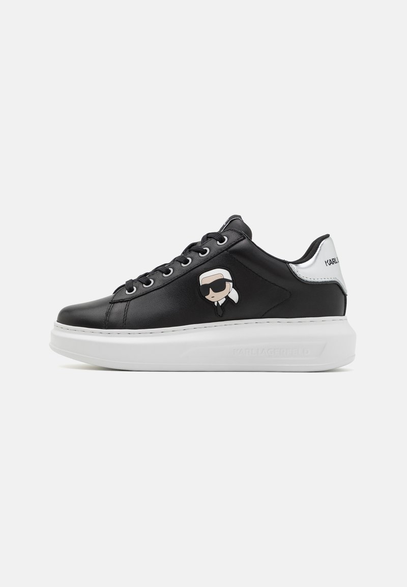 Schwarze Leder sneaker mit einer weißen Sohle, die ein Emblem eines Cartoon-Charakters an der Seite und weiße Akzente an der Ferse aufweist.