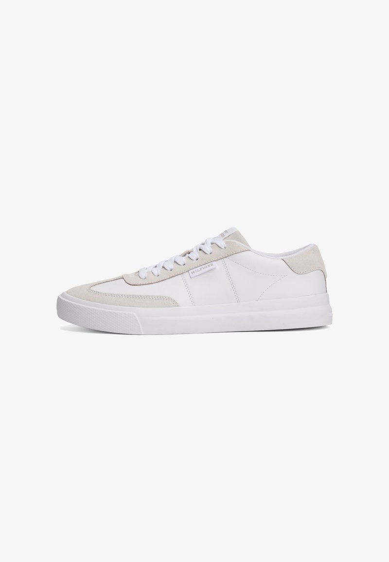 Białe skórzane sneakersy z beżowymi zamszowymi akcentami, okrągłym noskiem, płaską gumową podeszwą i białymi sznurowadłami; na boku znajduje się małe logo.