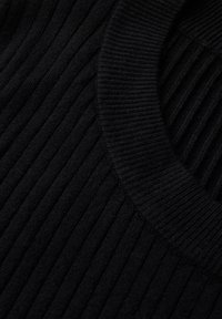 Maglione nero a coste con scollo rotondo e superficie testurizzata, che mette in risalto il tessuto morbido e i dettagli del motivo verticale.
