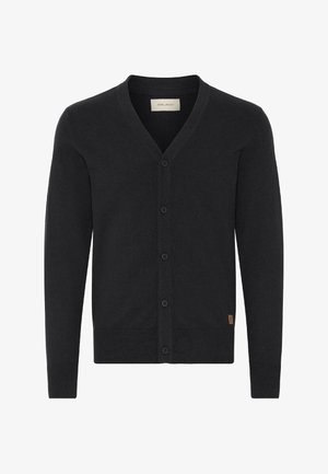 Svart knappegenser med lange ermer, V-hals, ribbestrikkede mansjetter og hem, samt en liten brun merkeetikett nær det nederste kanten.