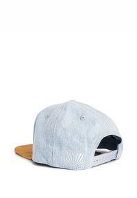 Gaiši zils džinsu cepure ar brūnu vizieri, kurai ir teksturēts apvalka logo un regulējams snapback aizdare.