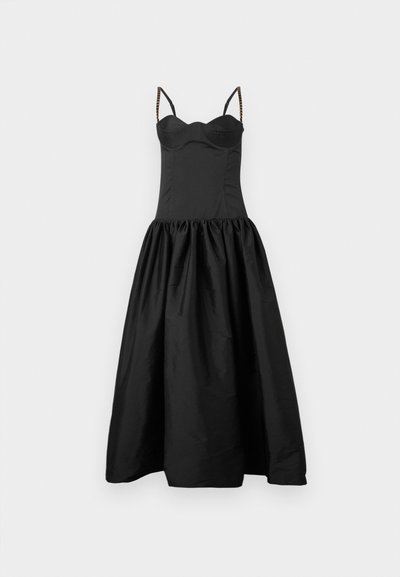 Melna kleita ar pieguļošu augšdaļu un izplestu, savāktu svārku. Iezīmējas ar plānām siksnām ar pērlēm. Gluda tekstūra un atturīgs dizains.