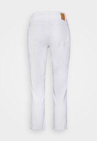 Jeans de denim blanco con un diseño de pierna recta, que presentan un dobladillo deshilachado sutil, dos bolsillos traseros y una etiqueta de marca de cuero marrón en la cintura.