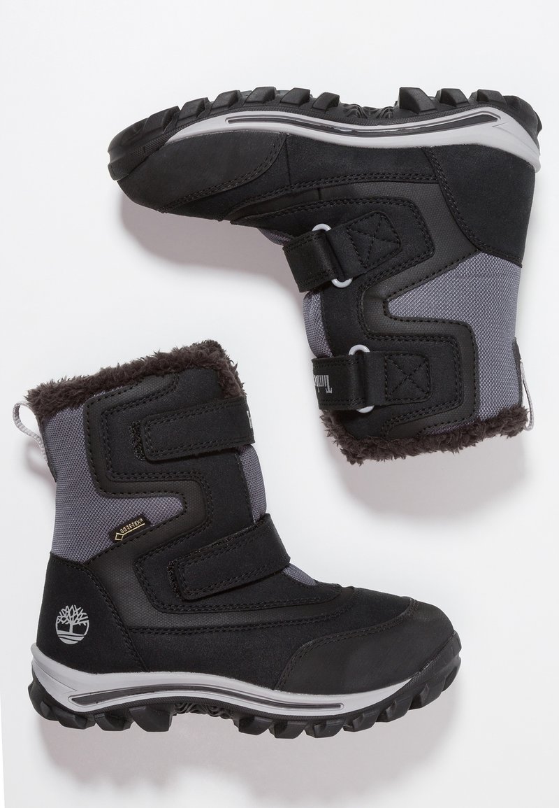 Bottes d'hiver noires et grises avec bandes Velcro, doublure en fourrure, semelles robustes et tissu Gore-Tex pour une protection imperméable.
