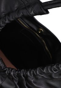 Borsa in pelle nera con bordo superiore arricciato, tasca interna con zip e texture morbida. Presenta un design elegante e minimalista.