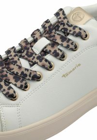 Sneaker in pelle bianca con lacci a stampa leopardata, occhielli dorati e logo impresso. Texture liscia e design leggero.