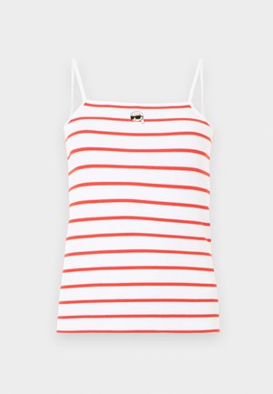 Bela rebrasta majica brez rokavov s tankimi naramnicami, horizontalnimi rdečimi črtami in majhnim vezenim obrazom s sončnimi očali in rutko blizu izreza.