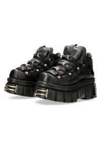 Schwarze Leder-Plateauschuhe mit dicken Sohlen, silbernen Akzenten und Schnürdesign. Mit runden Zehen und gepolsterter Knöchelstütze.