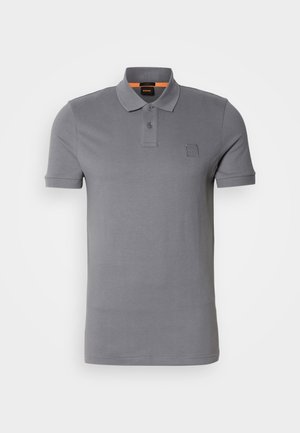 Siva polo majica iz mehkega materiala, z ovratnikom, kratkimi rokavi in majhnim logotipom na prsih. Opremljena z oranžno barvo znotraj ovratnika.