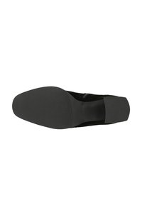 Scarpa in suede nera con punta rotonda, tacco flat e suola in gomma testurizzata caratterizzata da scanalature orizzontali per una migliore aderenza. Progettata per comfort e stabilità.