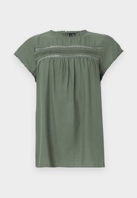 Detaillierte Damenbluse mit kurzen Ärmeln in Olivgrün, mit Spitzeinsätzen, plissiertem Vorderteil, rundem Ausschnitt und gewelltem Saum an Ärmeln und Kragen.