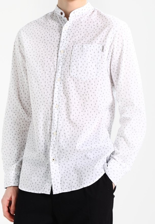 Vit långärmad skjorta med knapp-up och ett litet mönstrat tryck. Har en bandkrage och bröstficka. Tillverkad av lättviktigt tyg.