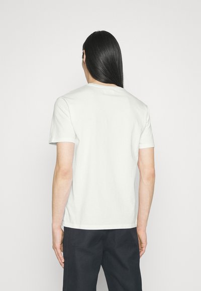 Šviesiai pilkas trumpavarstis marškinėliai, pagaminti iš minkštos medvilnės, su klasikiniu apvaliu kaklu ir tiesiu kirpimu, minimaliais siuvimo detalėmis gale.