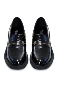 Mocassins en cuir verni noir avec un nez arrondi, des coutures décoratives et un accent jaune contrastant. La semelle plate en caoutchouc offre de la stabilité.