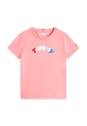 Roza kratka majica s rukavima s šarenim 3D slovima koja stvaraju natpis "TOMMY" preko prsa i s malim logotipom na lijevom rukavu.