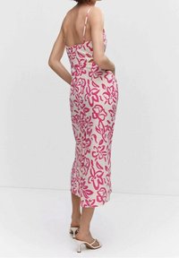 Kwiatowa sukienka na ramiączkach w odcieniach różu i kremu, z cienkimi ramiączkami i dopasowanym krojem. Gładki materiał o długości midi.