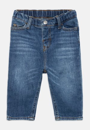 Jeans en denim pour bébé en bleu moyen avec une taille élastique, des coutures contrastées, un style cinq poches et une coupe droite.