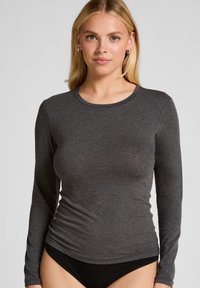 Langarm donkergrijs shirt gemaakt van zachte stof met een ronde hals. Slank model met een gladde textuur, gecombineerd met zwarte onderkleding.