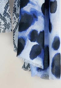 Écharpe en tissu léger présentant un motif abstrait bleu et noir, avec des bords frangés et une texture lisse.