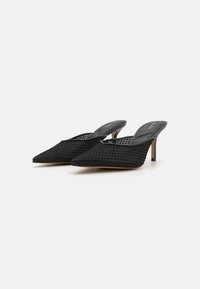 Sandale cu toc slingback din plasă neagră, cu vârf ascuțit și un design texturat. Au un toc subțire și branțuri negre căptușite.