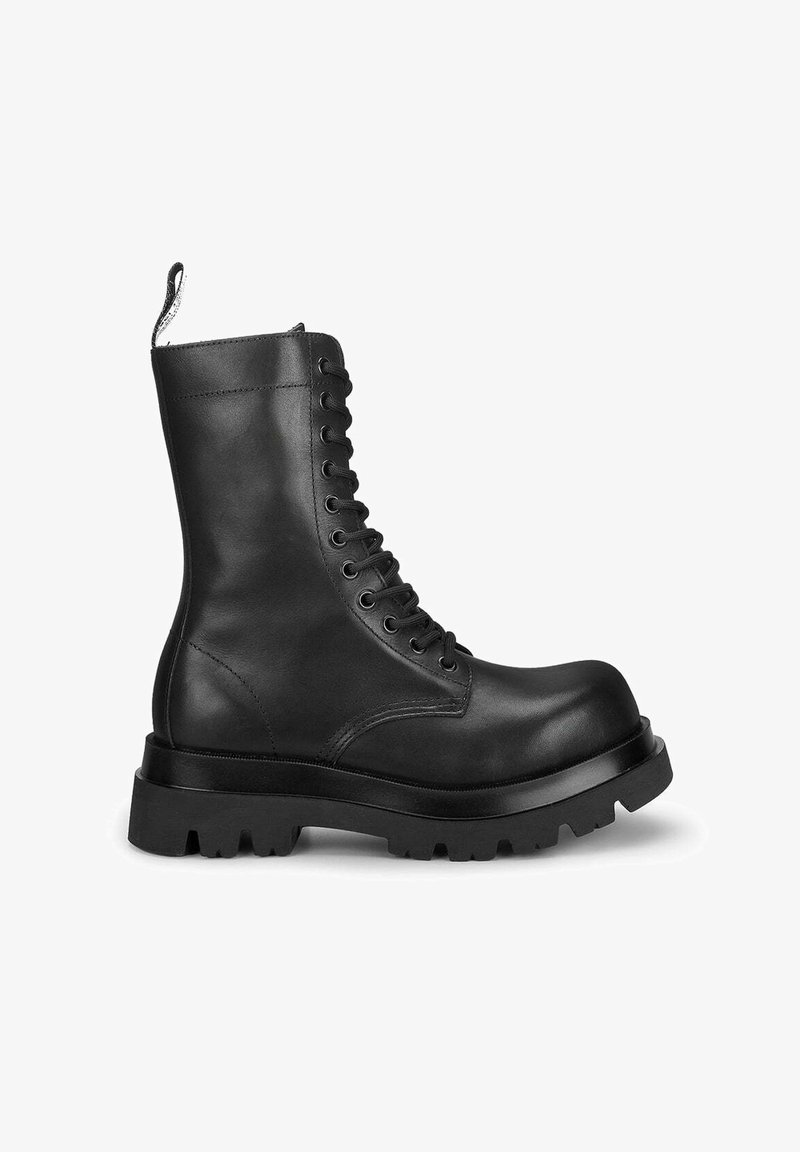 Stivali in pelle nera con lacci, suola spessa, punta rotonda e linguetta. Texture liscia con cuciture rinforzate e occhielli.