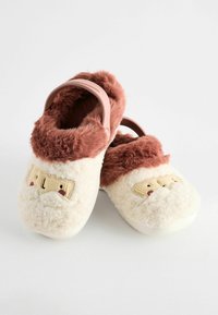 Chaussons avec un extérieur blanc duveteux et une bordure en fourrure marron, présentant un design de visage brodé. L'arrière possède une sangle moldée rose. Texture douce.