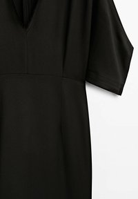 Sort kjole med V-hals og korte, brede ærmer. Fremstillet af glat stof med et minimalistisk design og rene linjer.