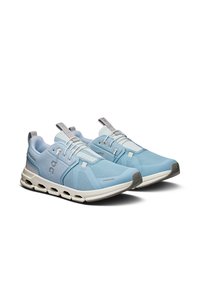 Baskets de sport bleu clair avec une tige en maille respirante, semelle intermédiaire blanche, accents gris et un design de semelle creuse unique.
