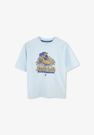 T-shirt in cotone azzurro chiaro con stampa grafica di stivali, testo "Timberland" e onde colorate. Maniche corte e scollatura rotonda.