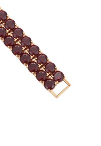Bracciale di cristallo rosso con collegamenti in metallo color oro. Presenta pietre circolari fissate in griffe, alternate a piccoli accenti rotondi.