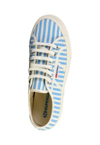 Zapatilla de lona a rayas azul y blanca con cordones blancos, suela de goma y marca en el costado. El material texturizado añade detalle.