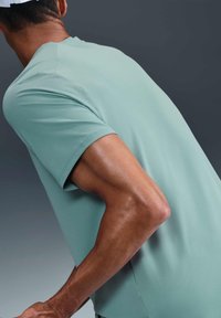 Korte mouwen, lichtblauw sportshirt gemaakt van gestructureerde stof, fitted ontwerp met een ronde hals en naden langs de schouders en zijkanten.