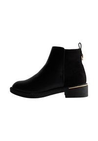 Botas tobilleras negras con parte superior de cuero liso, paneles laterales elásticos y un acento dorado en el tacón. Suela texturizada para mayor agarre y soporte.