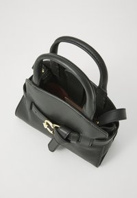 Borsa a mano in pelle nera con due manici superiori, hardware color oro e un dettaglio decorativo a fiocco. L'interno è foderato con un tessuto bordeaux.