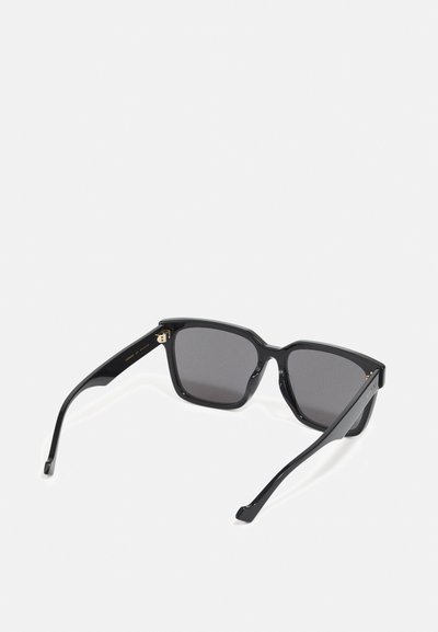 Ochelari de soare rectangulați negri cu lentile întunecate, rame din plastic texturat groase și detalii metalice pe tâmple.