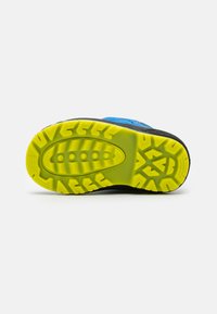 Suola di scarpa sportiva caratterizzata da uno strato esterno nero con una texture di gomma gialla brillante per la presa, e un accento di materiale superiore blu.