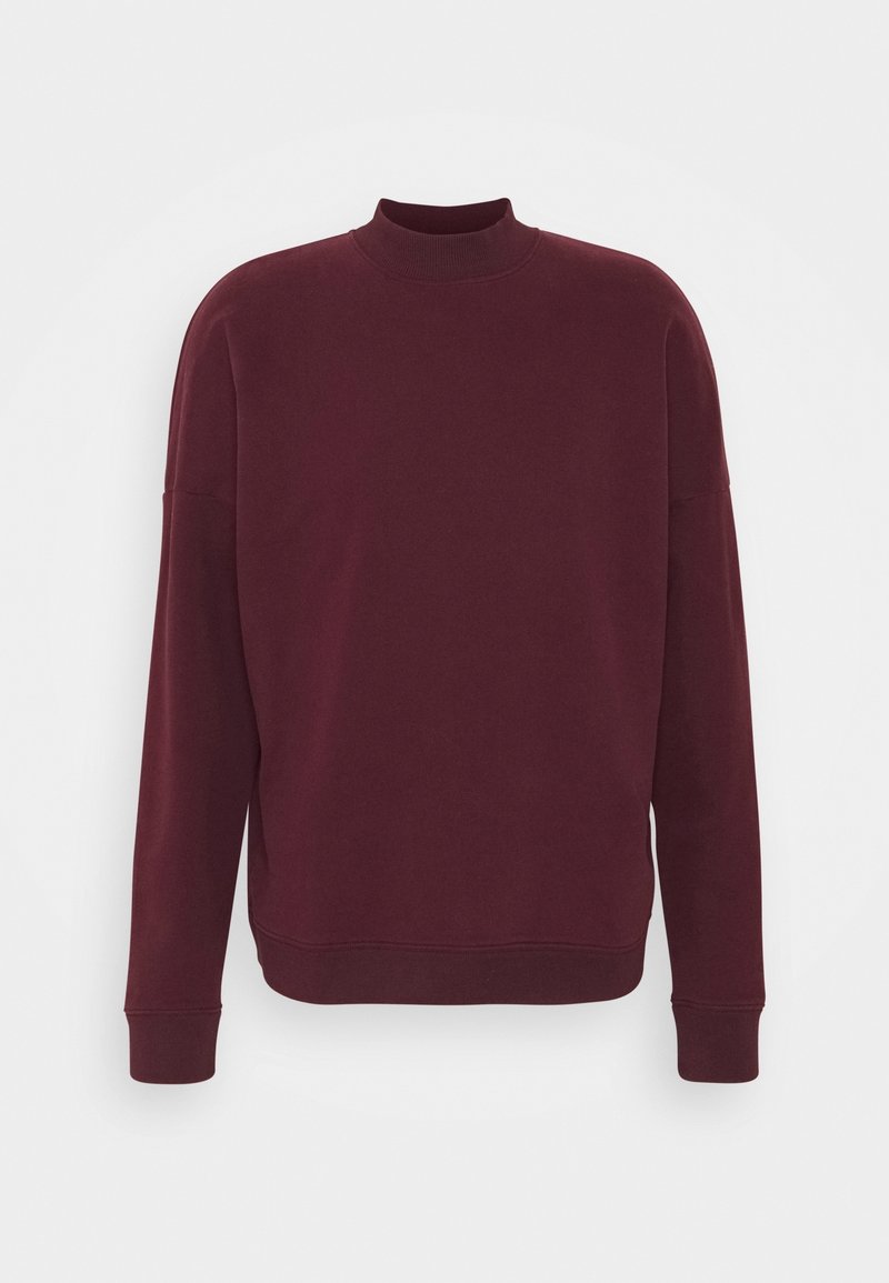 Sweat-shirt bordeaux avec col montant, manches longues et poignets côtelés. Texture lisse et coupe décontractée, avec des détails minimalistes.