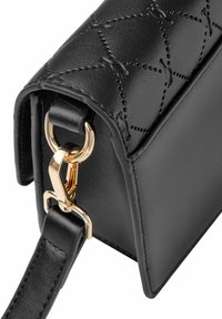 Czarna skórzana torebka z pikowanym wzorem, złotymi akcentami, strukturalnym kształtem i regulowanym paskiem. Gładka tekstura i kanciasty design.