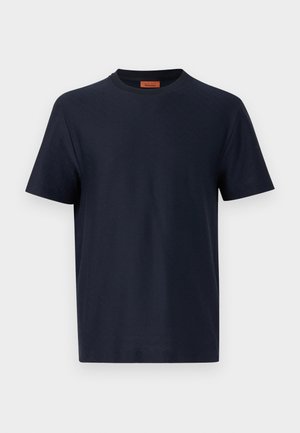 T-shirt blu navy a maniche corte con collo rotondo, caratterizzata da una sottile texture a zigzag e etichetta interna arancione sul collo, su sfondo bianco uniforme.
