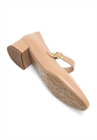 Beige kožená bota s nízkým blokovým podpatkem, nastavitelným řemínkem kolem kotníku se zlatým sponou a texturovanou gumovou podrážkou s vzorovaným designem.