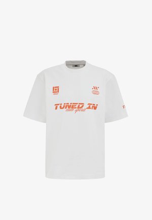 Weißes T-Shirt mit kurzen Ärmeln, orangefarbener Schrift "Tuned In club spirit" und grafischen Logos auf Brust und Ärmel.