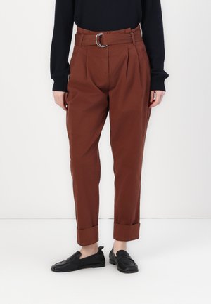 Pantaloni color ruggine con vita regolabile dotata di una fibbia circolare, gambe affusolate con orli arrotolati, realizzati in un tessuto liscio.