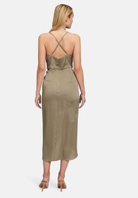 Oliwkowa satynowa midi sukienka z dopasowanym gorsetem, krzyżującymi się ramiączkami na plecach i zapięciem na zamek z tyłu, prezentująca gładką teksturę.