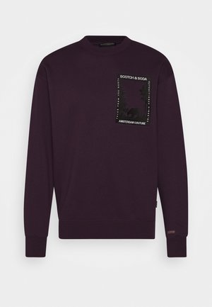 Dunkellila Sweatshirt mit Rundhalsausschnitt, Rippbündchen an Ärmeln und Saum, mit einem rechteckigen Patch mit der Aufschrift "Scotch & Soda" und einem abstrakten Naturmuster auf der Brust.