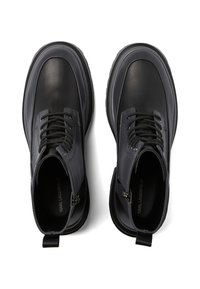 Botas negras hasta el tobillo con parte superior de cuero liso, punta redonda y suela de goma texturizada. Incluye cordones, una cremallera y una lengüeta.