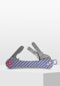 Multiverktyg med handtag i lila kolfiber. Inkluderar metallnycklar och verktyg, med en röd schweizisk kors emblem och silverfärgade detaljer.