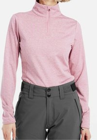 Rosa långärmad zip-hals topp i texturerad tyg, kombinerad med grå byxor som har två knappar och sidofickor.