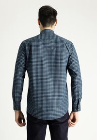Camicia a maniche lunghe a quadri in blu scuro e verde, con colletto button-down e orlo curvo, realizzata in un morbido tessuto misto cotone.